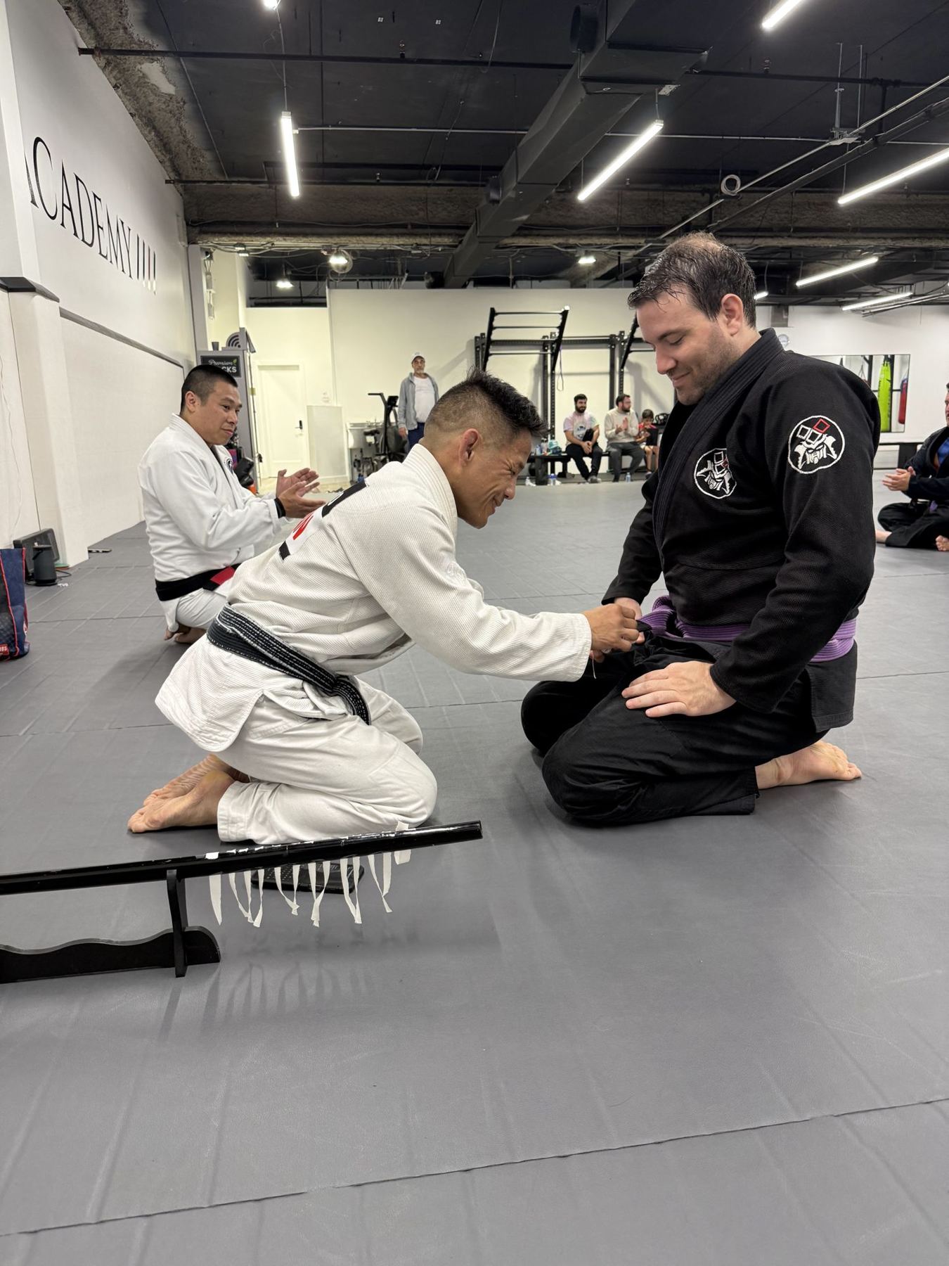 Instructor promoting a student to purple belt