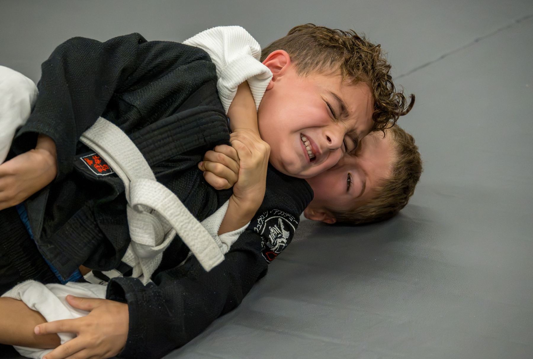 Two kids battling for position in a gi match
